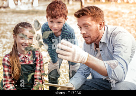 Serious teacher with beard wearing white garden gloves Stock Photo