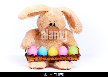 Stuffed soft rabbit with colorful bright painted eggs. Stock Photo