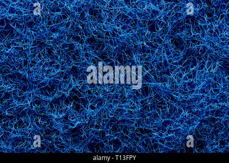 The texture of the surface of interwoven blue threads of abrasive synthetic fiber. Stock Photo