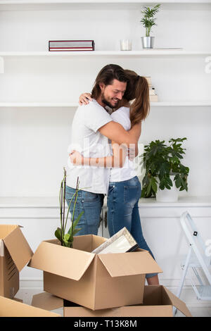 Couple with cardboard boxes hugging in new home Stock Photo