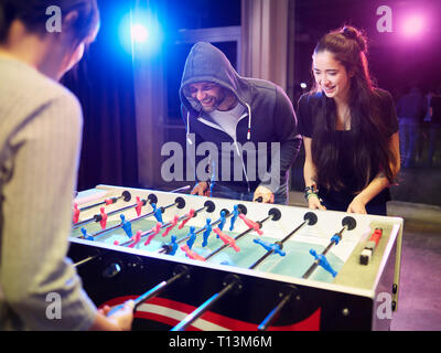 Happy friends playing foosball Stock Photo