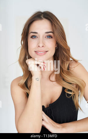 Portrait of smiling young woman wearing black dress Stock Photo
