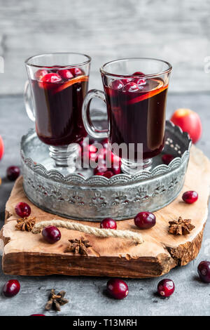 Mulled wine glasses on table in front of burning fireplace. Stock