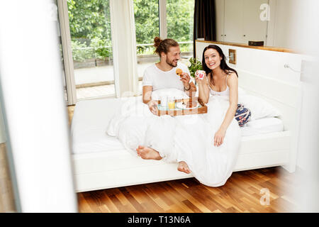 Affectionate couple having breakfast in bed Stock Photo