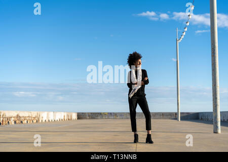 Woman dressed in black enjoying sunlight Stock Photo