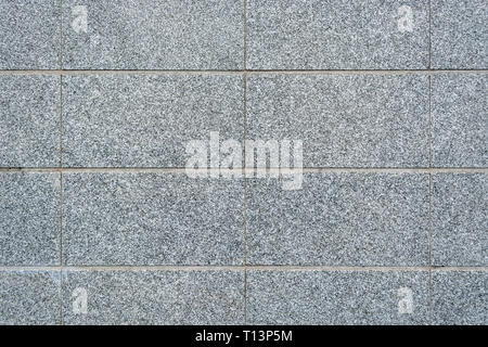 Fragment of a wall of gray speckled slabs for use as a background. Stock Photo