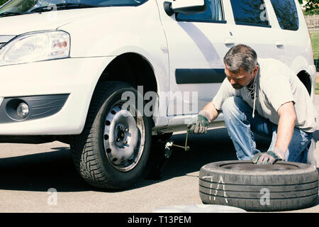 Mature man changing car tires, top view Stock Photo