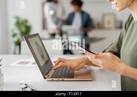 Young woman working in office, using laptop Stock Photo