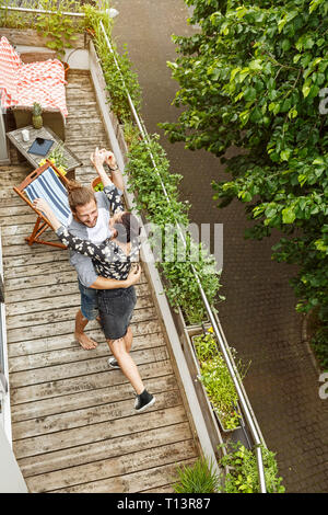 Young affectionate couple dancing on their balcony Stock Photo