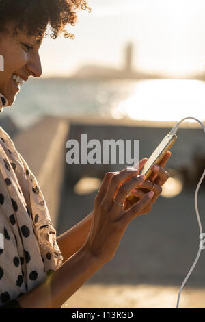 Smiling woman using smartphone Stock Photo