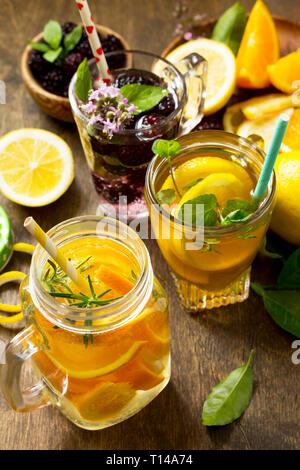 Summer drink set close-up. Refreshing summer berry Lemonade, lemon mint Tea and orange Lemonade with rosemary. Stock Photo