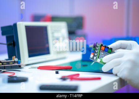 Development of electronic devices in the modern electronics laboratory, on a table, microprocessor oscilloscope and multimeter Stock Photo