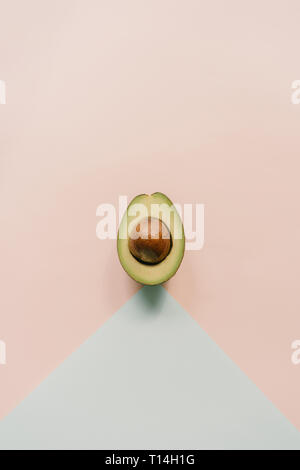 Top view on half avocado on minimalistic background Stock Photo