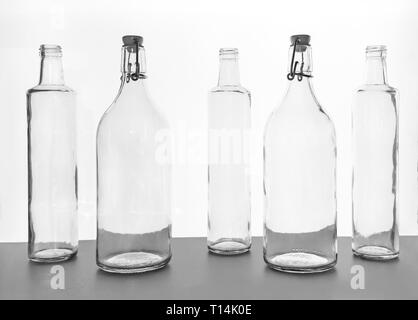 Empty transparent glass bottles silhouette on the white illuminate from behind background Stock Photo