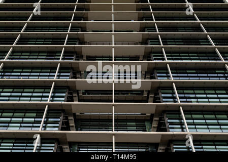 Bottom view glass grey square Windows of modern city business building skyscraper. Receding perspective, movement forward and up. Bottom view of offic Stock Photo