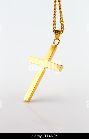 Golden cross pendant on the gold chain on white background ( 24K pure gold necklace christian) Stock Photo