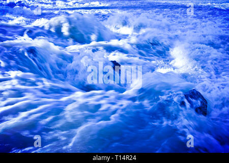 Rushing waters of a swollen river during the rainy season - toned image Stock Photo