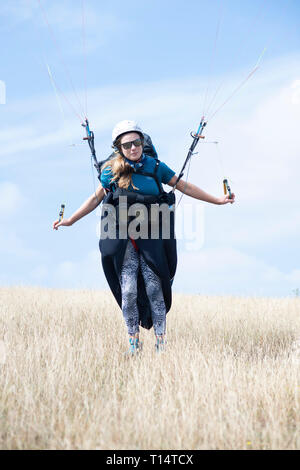 A young female para glider takes off from the South Downs. Stock Photo