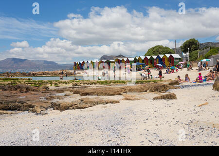 colourful beach huts at St James beach and tidal pool with people enjoying Summer sun and holiday lifestyle Cape Peninsula, Cape Town, South Africa Stock Photo