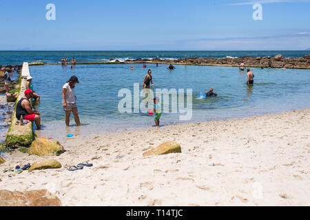 tidal swimming pool at St James beach with people cooling down  in Summer on holiday  vacation at False Bay, Cape Peninsula, Cape Town, South Africa Stock Photo