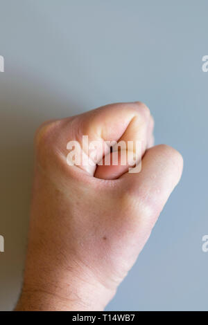 fist on gray background. The concept of domestic violence. Male rudeness and violence. vertical photo. Stock Photo