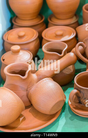 Lots of traditional ukrainian handmade clay pottery production. brown pottery. Clay plates and cups. vertical photo. Stock Photo