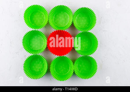 Brightly green and red colored paper baking cups for cupcakes or muffins on light grey conkrete background, copy space Stock Photo
