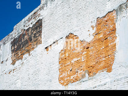 Nature has worn away some plaster revealing the underlying brick on this old building. Stock Photo