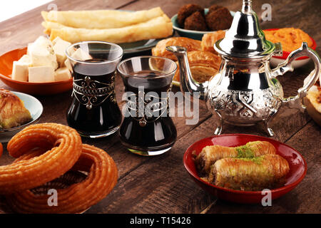 Middle eastern or arabic dishes and assorted meze, concrete rustic background. Turkish Dessert Baklava with pistachio. falafel with hommos.  Halal foo
