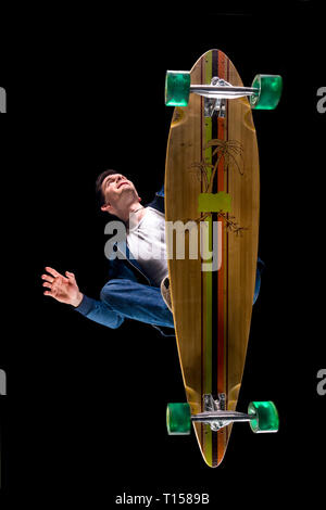 Young man driving longboard seen from below Stock Photo