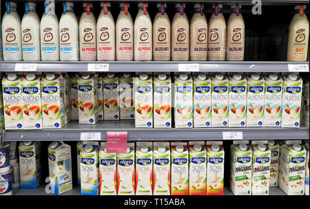 A variety of dairy free vegan milk alternatives cartons bottles on a refrigeration shelf at Waitrose supermarket in London England UK  KATHY DEWITT Stock Photo