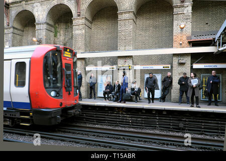 Overground underground tube train approaching Barbican Station platform with passengers waiting to board the carriage London England UK KATHY DEWITT Stock Photo