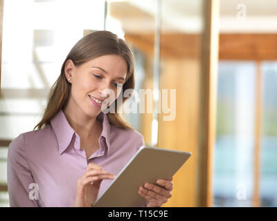 Smiling businesswoman using tablet in office Stock Photo