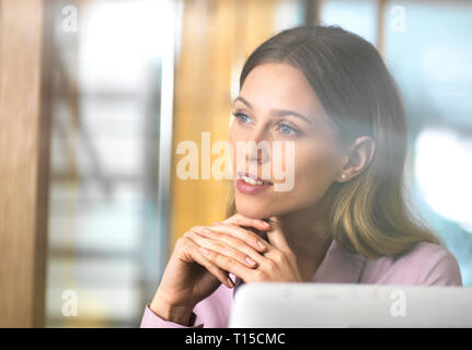 Confident businesswoman in office thinking Stock Photo