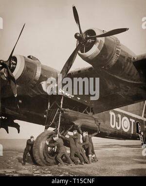 Ground crew moving a 20 ton Short Stirling, British heavy bomber of the Second World War. The first four-engined bomber to be introduced into Royal Air Force squadron service in early 1941. The Stirling was relegated to second line duties from late 1943, due to the increasing availability of the more capable Handley Page Halifax and Avro Lancaster, which took over the strategic bombing of Germany. Stock Photo