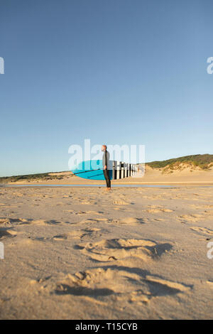 Spain, Andalusia, Tarifa, man with stand up paddle board on the beach Stock Photo