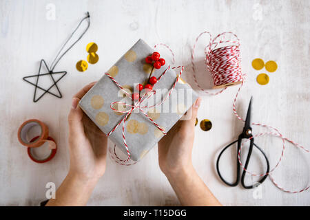 Girl's hands holding wrapped Christmas present Stock Photo