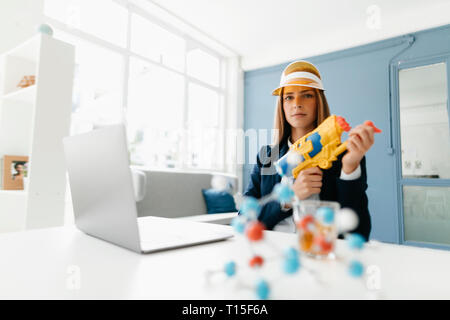 Female scientist holding water gun, studying molecules Stock Photo