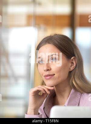 Confident businesswoman in office thinking Stock Photo