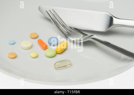 Pills on a plate with cutlery Stock Photo