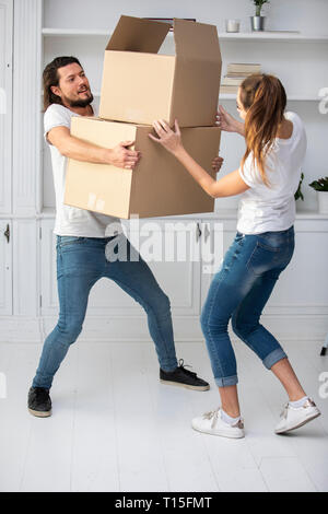 Couple with girlfriend carrying cardboard boxes in new home Stock Photo