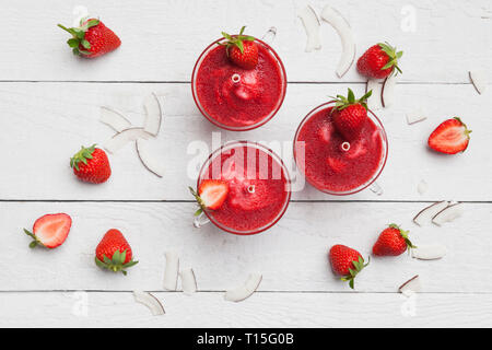 Homemade strawberry-coconut ice lollies with fresh strawberries and coconut slices on wooden background Stock Photo