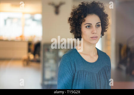 Thoughtful woman looking out of window at home Stock Photo