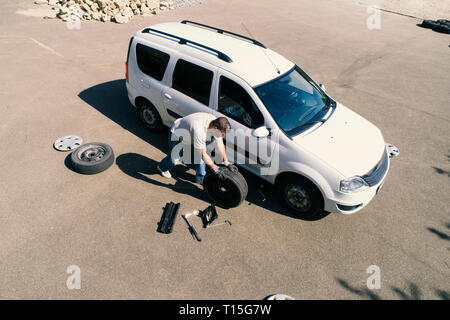 Mature man changing car tires Stock Photo