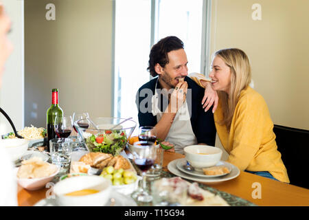 Friends having fun, eating lunch together, couple flirting at the table Stock Photo