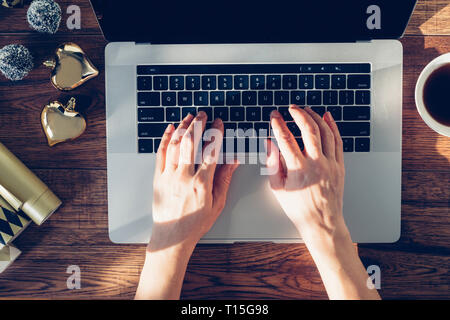 Woman's hands typing on laptop, top view Stock Photo