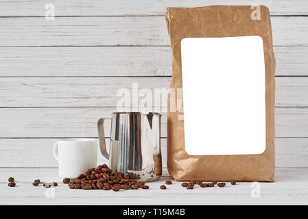 Coffee cup, craft paper bag and stainless pitcher on white background, copy space Stock Photo