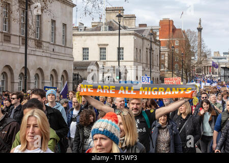 Whitehall, London, UK; 23rd March 2019; Protesters March During the anti-Brexit 'Put it to the People' March in Central London. One man Holds Aloft a Scarf With Message in Support of Migrants Stock Photo