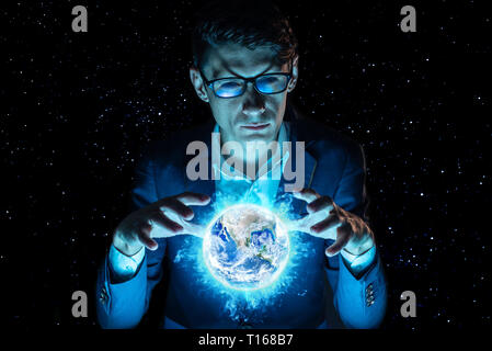 A man businessman holding hands over a blue glowing sphere in the form of planet earth. Elements furnished by NASA Stock Photo