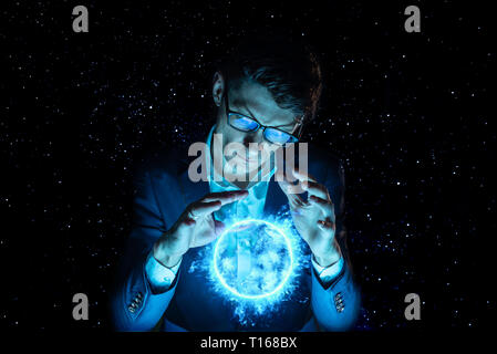 A man businessman holding hands over a blue glowing plasma sphere. Magic prediction and foresight in business and Finance Stock Photo